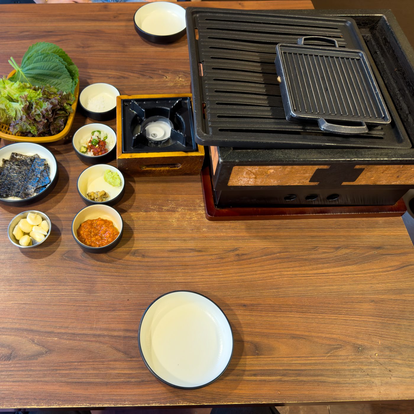 큰 불판 옆에 연료로 데우는 작은 불판과 반찬