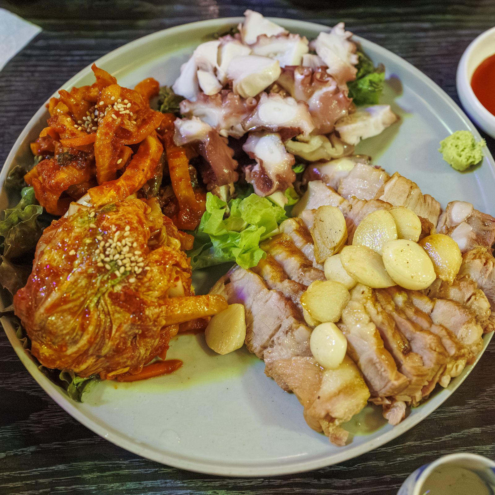 미러볼밥술상의 대표 메뉴 미러볼 문어삼합: 문어, 보쌈, 김치, 마늘